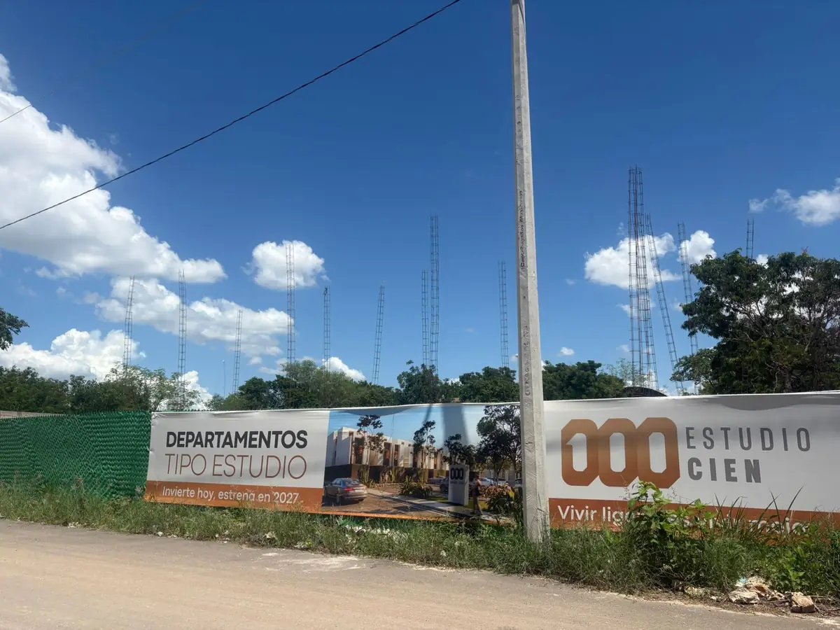 Frente del terreno de Estudio Cien en Mérida con la valla de obra: departamentos tipo estudio, invierte hoy y estrena en 2027